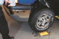 With the vehicle raised one foot (30 cm) off the ground, push down on the vehicle to check if it ...