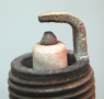 A normally worn spark plug that has  a tapered platinum-tipped center electrode.