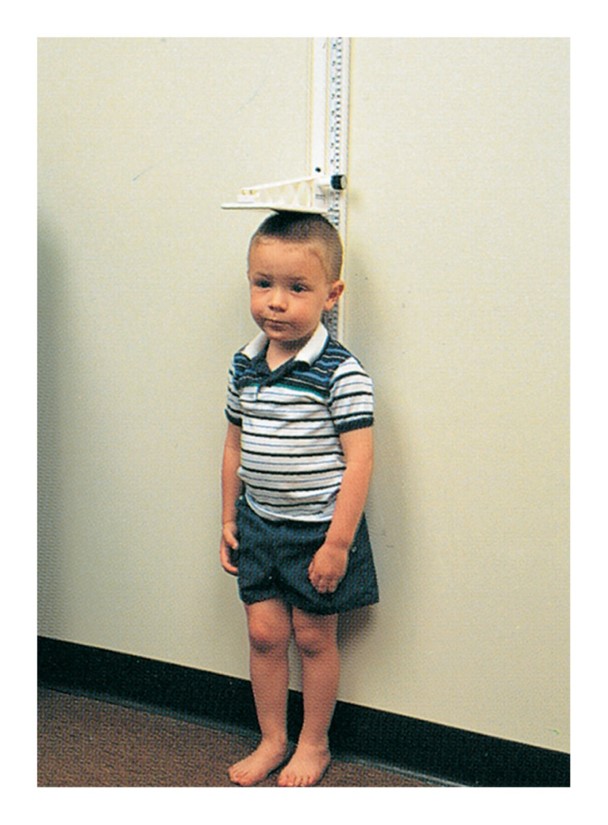 Measuring a child’s height with a measuring stick