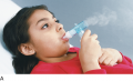 A Girl Breathes Mist Through a Nebulizer, with a Bite Piece in Her Mouth