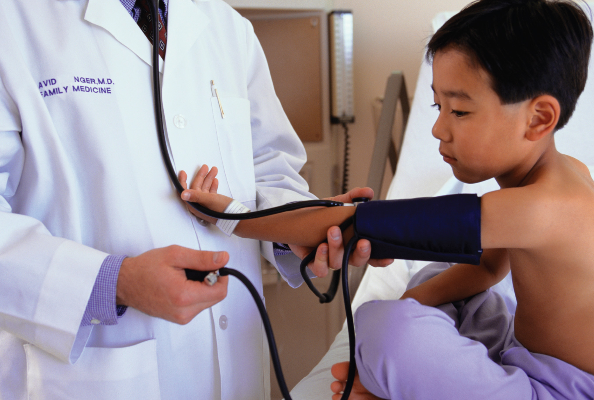 Sphygmomanometry. Photograph of a physician taking blood pressure readings with the use of a sphygmo