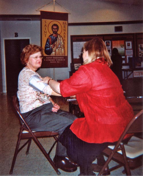 A parish nurse checks the blood pressure of a church member