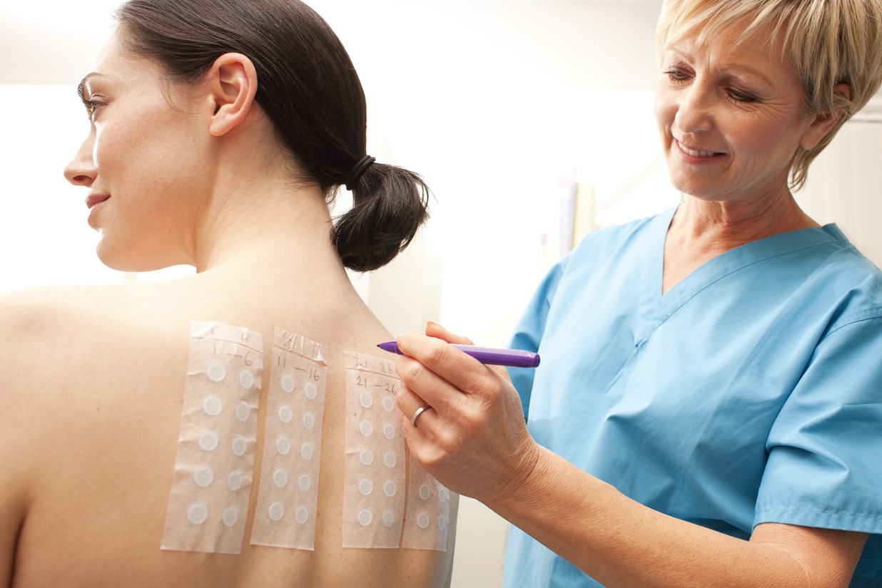 A medical assistant labels the allergens for a patch test. 