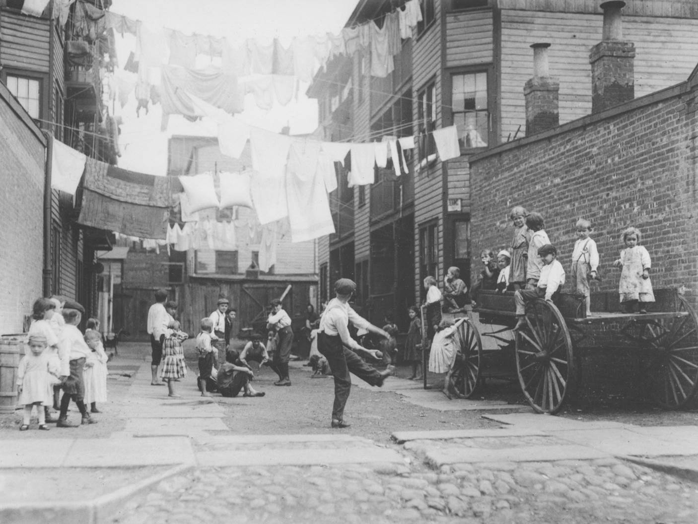 Lewis Hine’s 1910 photograph shows a tenement alley in New York City. More famous for his “unsettlin