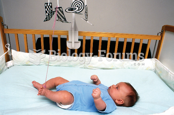  An infant lying in the crib, looking at the mobiles hanging above him.
